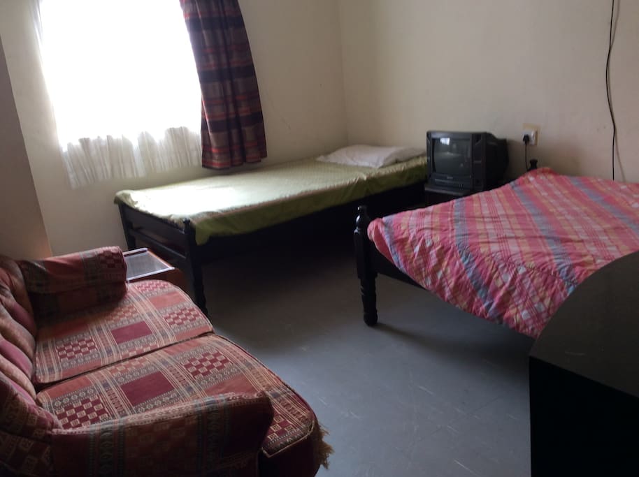Bedroom with two twin beds comfortable fits 2 with a Tv, built in secure wardrobe, a comfy couch to relax on as you watch some news.