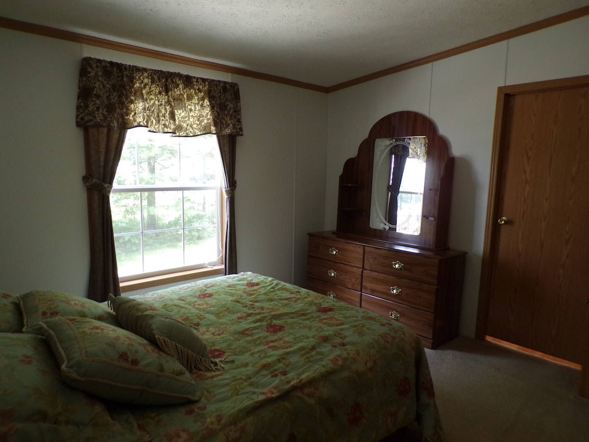 Основна спалня с двойно легло, показваща вратата на главната баня.