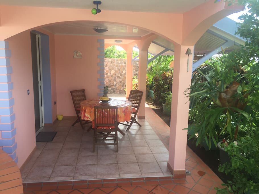 La terrasse à l'entrée de votre logement offre un bel espace meublé d'une table en bois assortie de ses chaises.