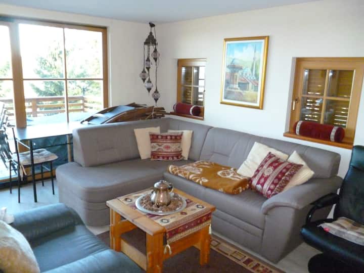 Sala de estar con TV y asientos extensibles