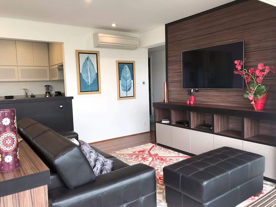 Sala de estar aconchegante, com sofás em couro e ar condicionado
