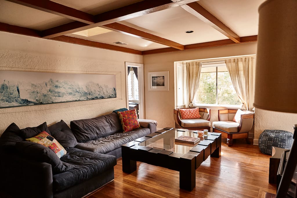 Living room with large comfy couch, fireplace, flat screen and views.