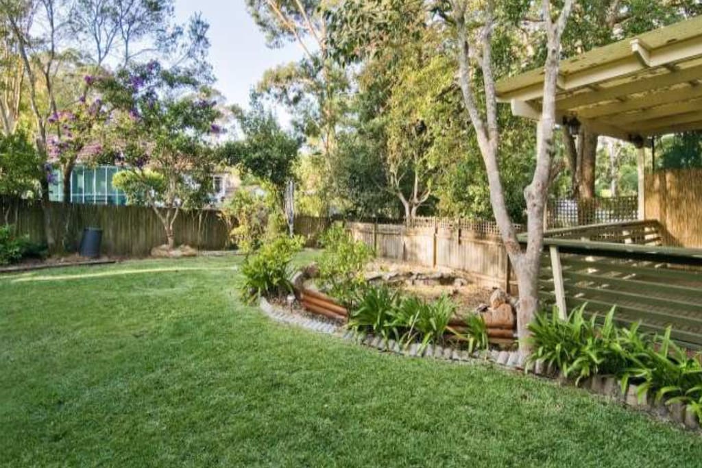 Large, leafy sunny garden and deck