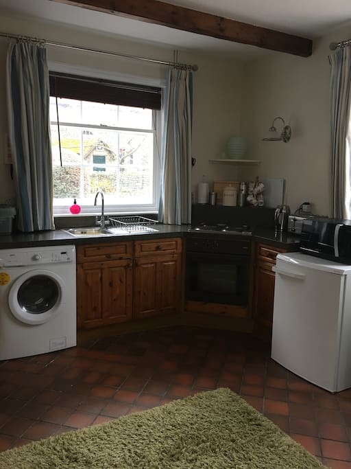 Newly decorated kitchen area with new blind, curtains and wall light.