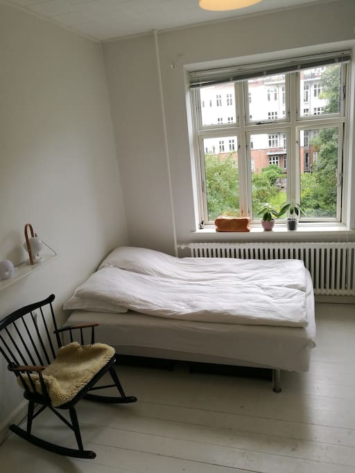 Soveværelse med udsigt til stor gårdhave.