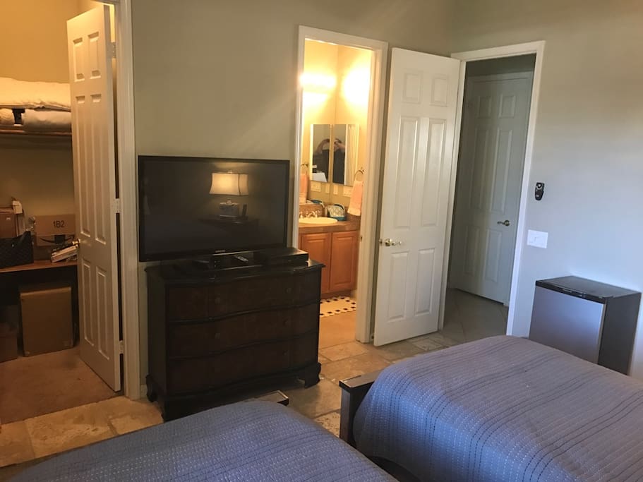 View of the closet, tv, bathroom and mini fridge