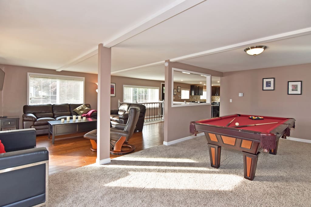 The living room is next to the game room in this open layout.