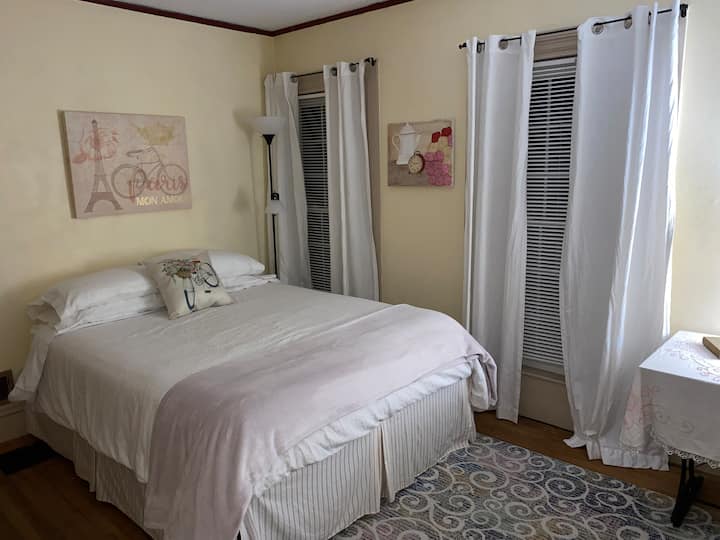 רו דו סוליי - רחוב השמש. חדר השינה שלנו בפריז עם מיטת קווין סייז וכיסא נדנדה.