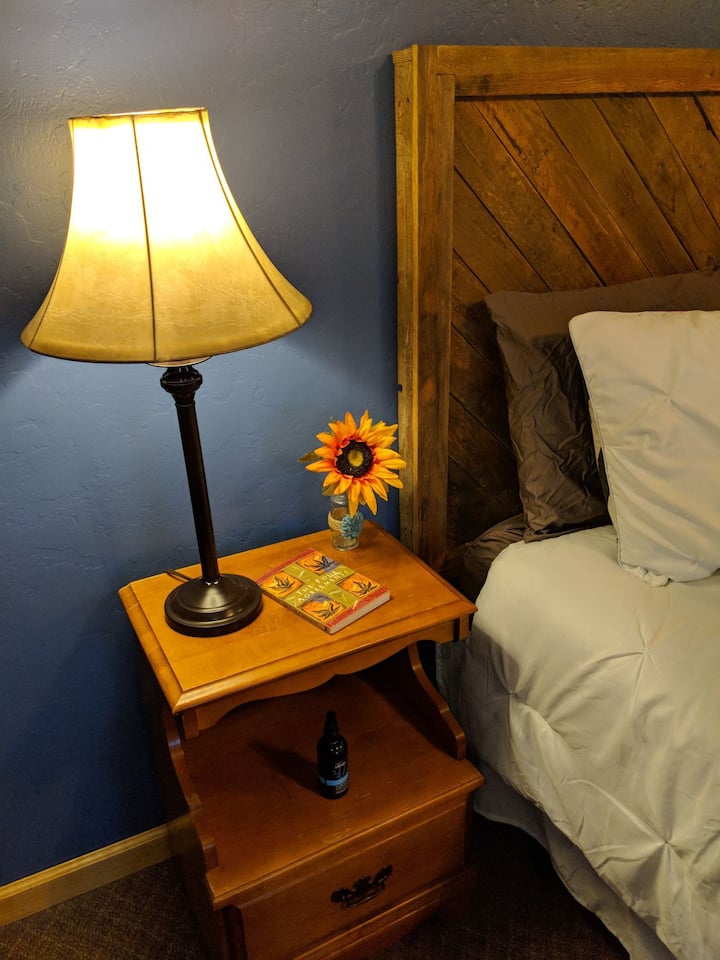 Nightstand next to Queen bed with lamp. 