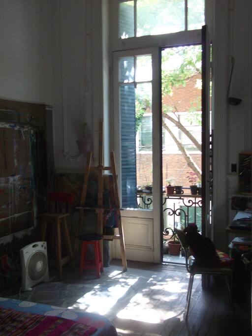 hay un escritorio y una madera en la pared para pegar papeles y pintar. balcon a la calle con flores q se deben regar.