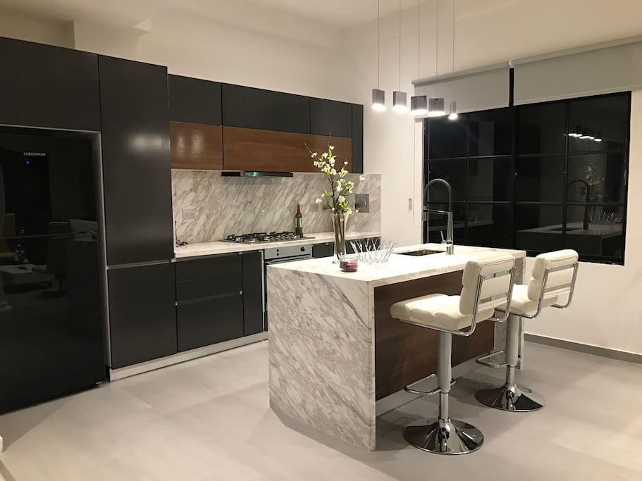 Luxury brand new designer kitchen with top of the line appliances and marble countertops.