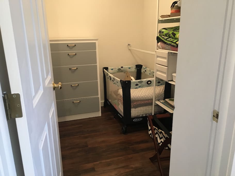 Large walk-in closet, dresser, Graco play and pack for infants.