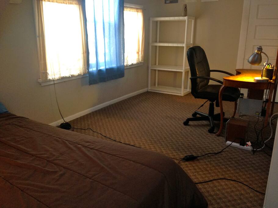 Comfortable office chair, lamp, and antique desk. Shelving to store your things.