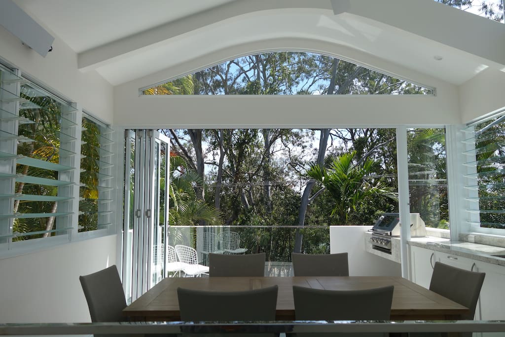 Upstairs dining and sunroom looking out towards veranda & built-in granite bench/BBQ