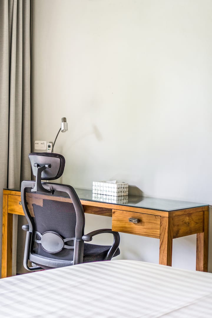 Просторна стая с високи дървени тавани и гледка към басейна, има съблекалня и работно бюро.