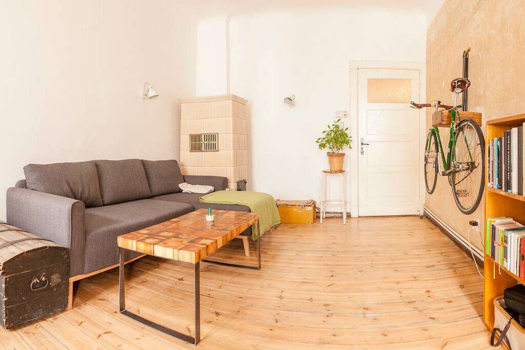 Livingroom with sofa, tile stove, bike and self-made table
