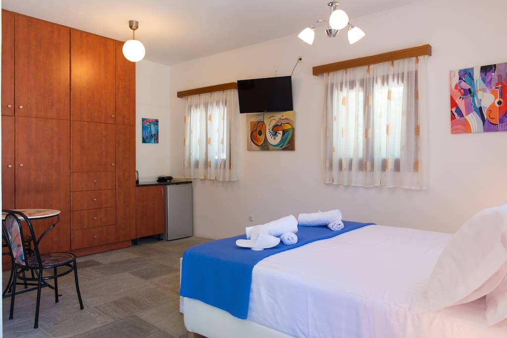 The 32" satellite smart TV is opposite the bed. A small refrigerator, a kettle, a coffee maker and a sandwich maker are also available.