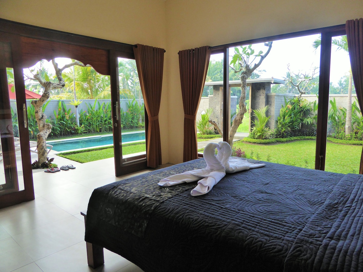 תיהנו מטרקלין אחר הצהריים על המיטה שלכם המשקיף על הבריכה והגינה בחדר השינה 1