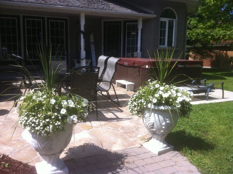 Backyard stone patio with 6 chair patio set, 4 burner bbq and hot tub