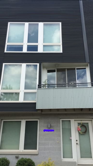 View of three story townhome with rooftop patio.