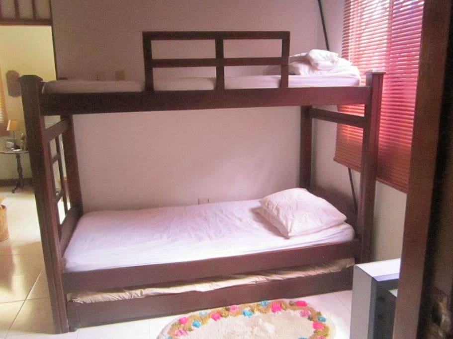 Segundo dormitorio con dos camas sencillas, closet, baño privado, ventilador y aire acondicionado