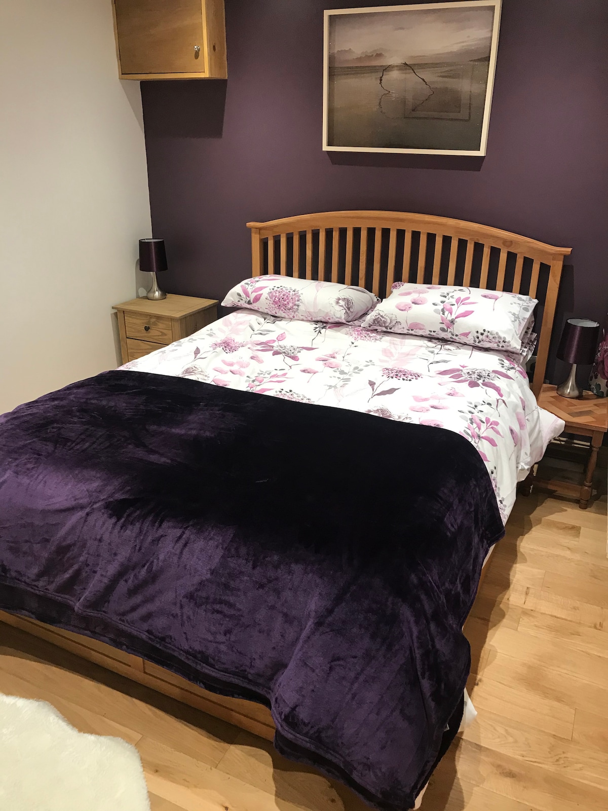 Bedroom with closet, king size bed, lamps, chest of drawers and hairdryer.