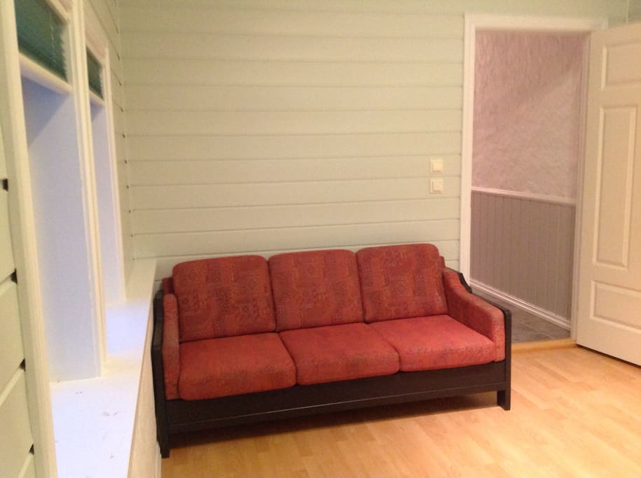 Lyst og trivelig rom med dobbeltseng og sofa.