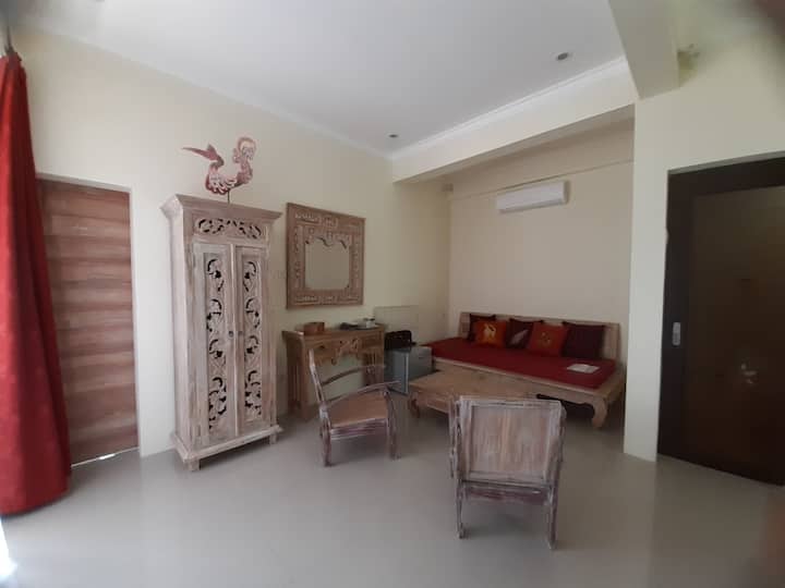 套房内有休息区和单人沙发床。一扇门通往另一个房间，通往独立卫生间