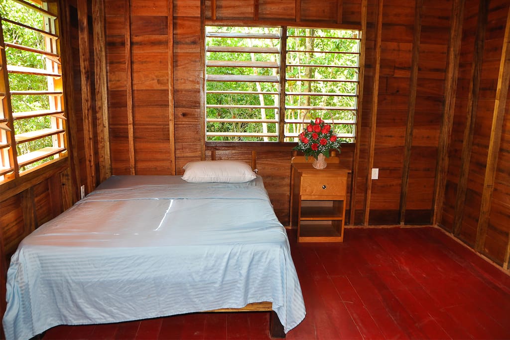 The double bed with direct view on the jungle.