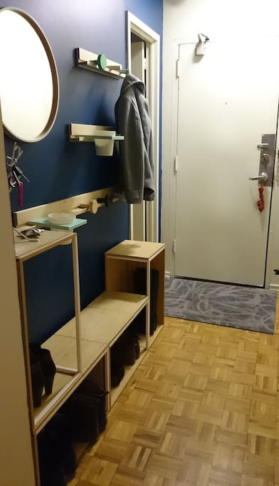 Entryway into the apartment, with coat hooks and shoe storage
