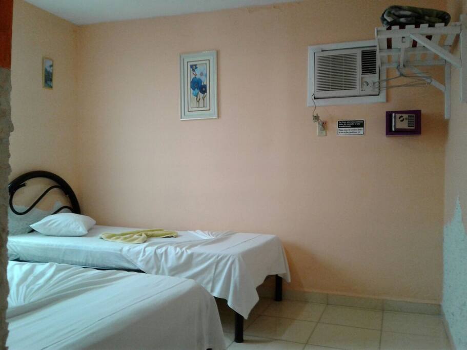 2 camas, aire acondicionado, percha y caja de seguridad.