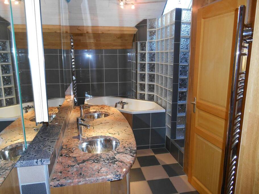 salle de bain avec baignoire et douche et wc fermé sur la droite