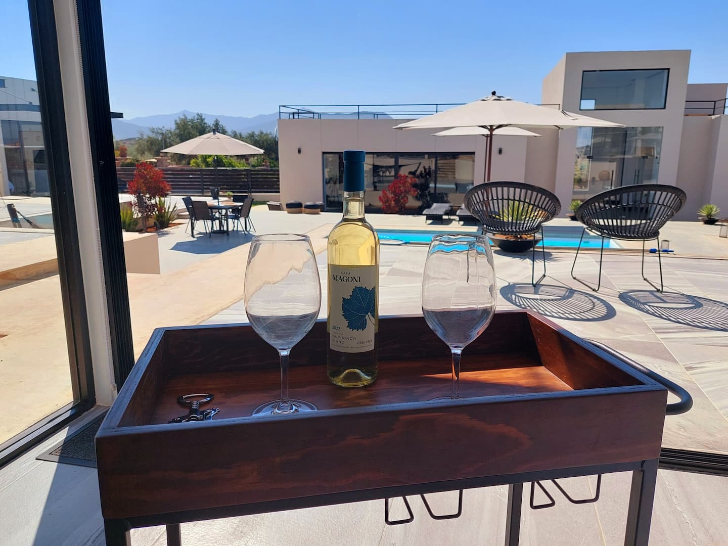 Wine and glasses on a tray by the pool
