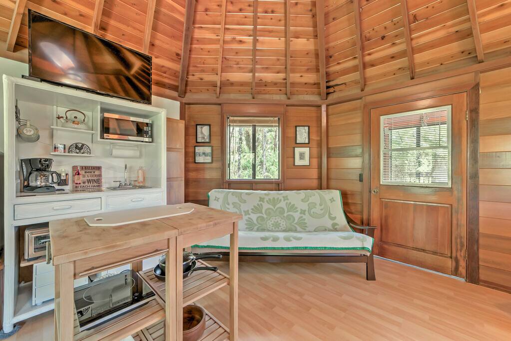 Step inside to be greeted by a vaulted wooden ceiling framing a bright, inviting space with 360 degrees of lush jungle views out of every window.