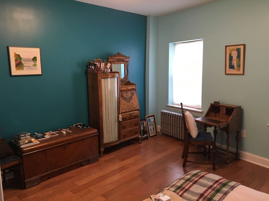 The other side of the room has an antique desk that is usable for a laptop