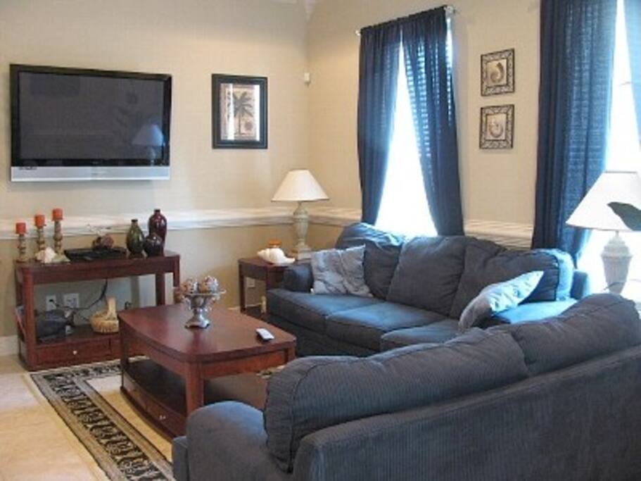 Living room with sleeper sofa and big screen TV.