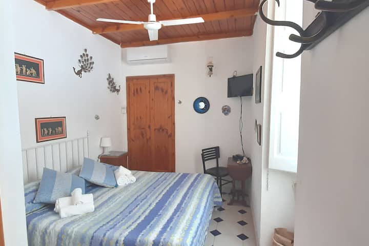Slaapkamer met een tweepersoonsbed, peddelventilator, airconditioning, groot raam,kleine aan de muur gemonteerde kast, 2 nachtkastjes en abat jour.
Weinig slecht.