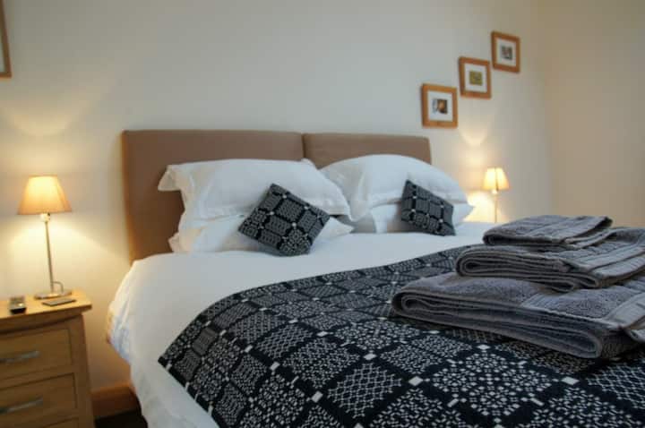 Comfortable bedroom with zip and link bed and ensuite in farm self catering cottage near Criccieth