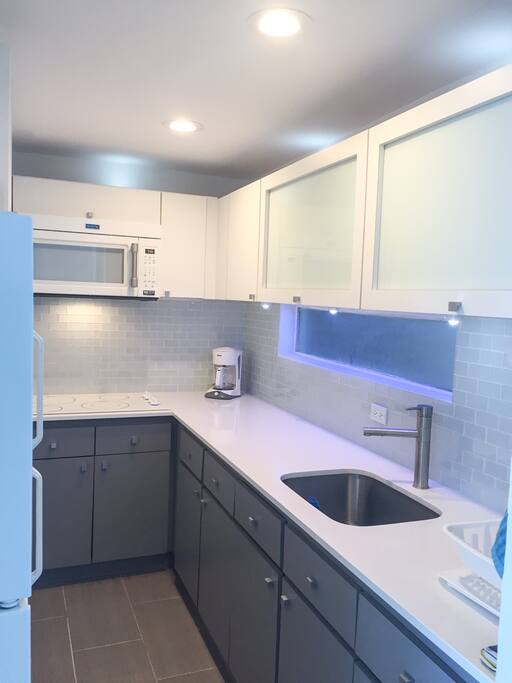 New modern kitchen with white quartz countertops.