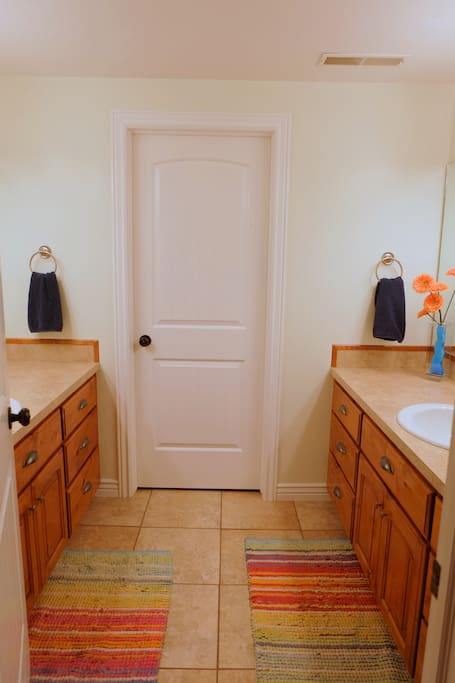 Double sinks, lots of counter space. Door separates shower/toilet area