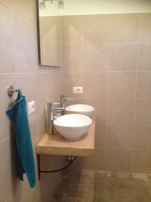 moderne ruime badkamer met toilet, inloopdouche en dubbele wastafel.