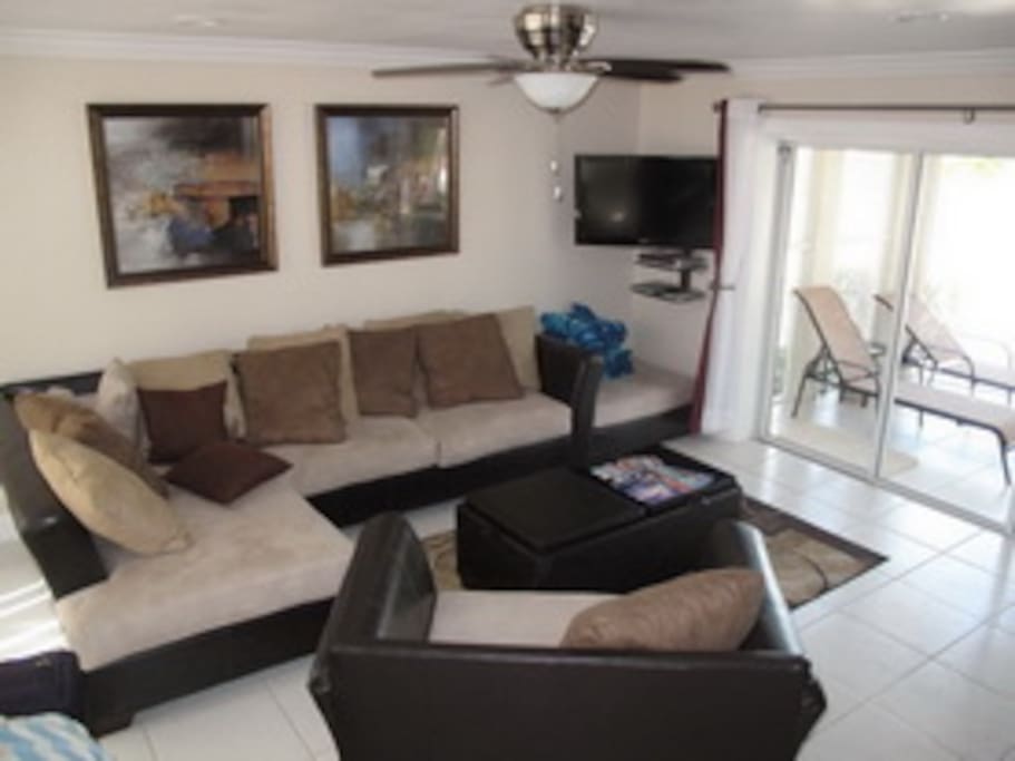 The living room is beautiful appointed with all new furniture and large white tile floors throughout.