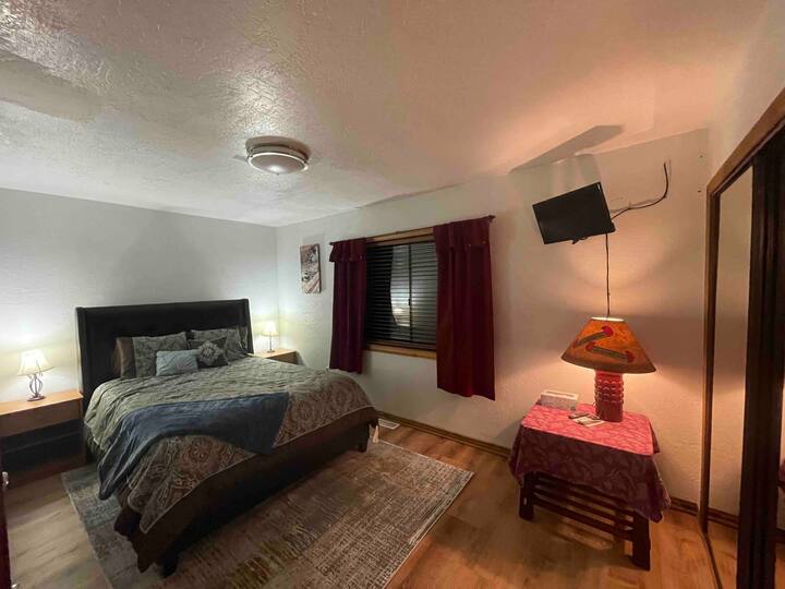 Cama tamaño queen de lujo con mucho espacio en este dormitorio