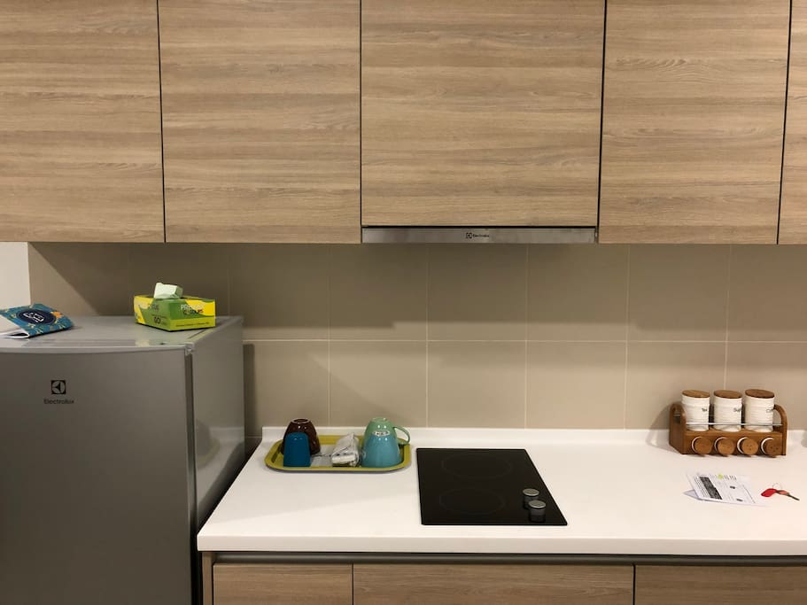 A very functional kitchen, with one-door refrigerator, hood & hob, kettle, rice cooker, toaster and other kitchen utensils.