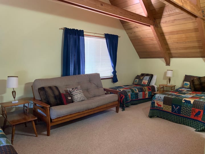 Bovenslaapkamer #2, met een tweepersoonsbed, twee eenpersoonsbedden en een dubbele futon