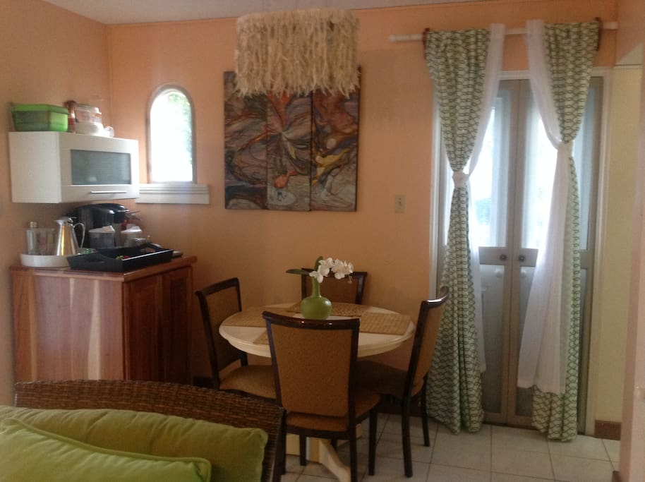 Living/Dining room with 4 seater dining table, microwave & coffee maker
