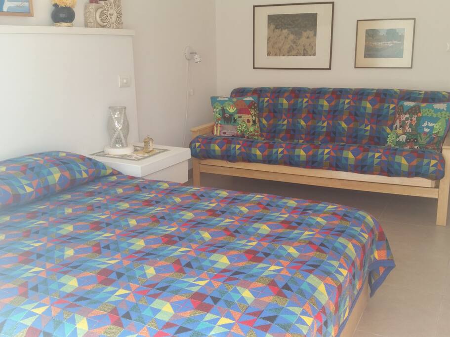Primera habitación (H1) Cómoda cama Queen Size y un futón al lado para un tercer huésped. Entrada y salida independiente.