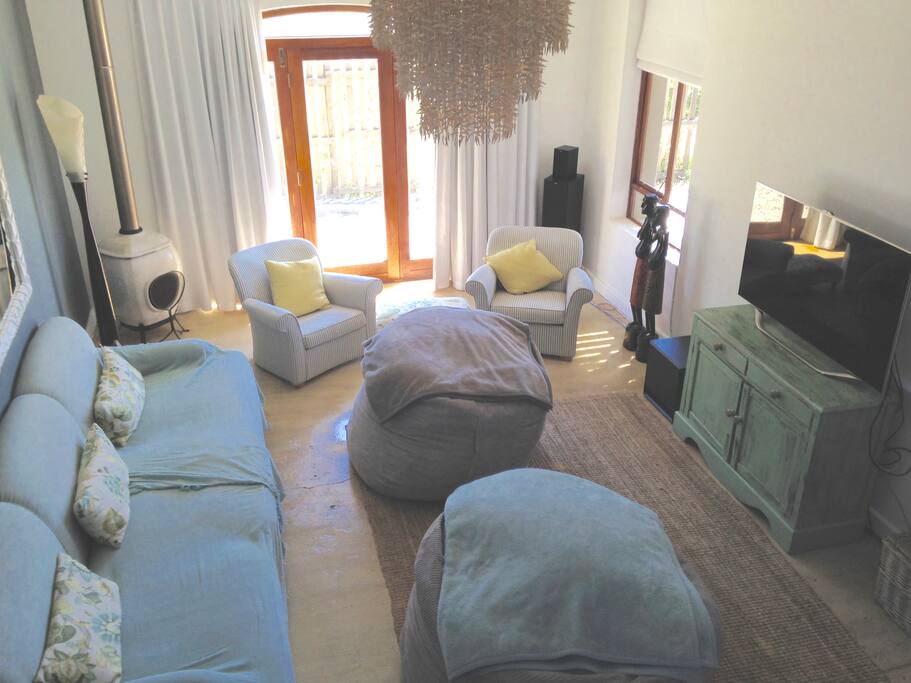 Main lounge area with widescreen TV and work desk.