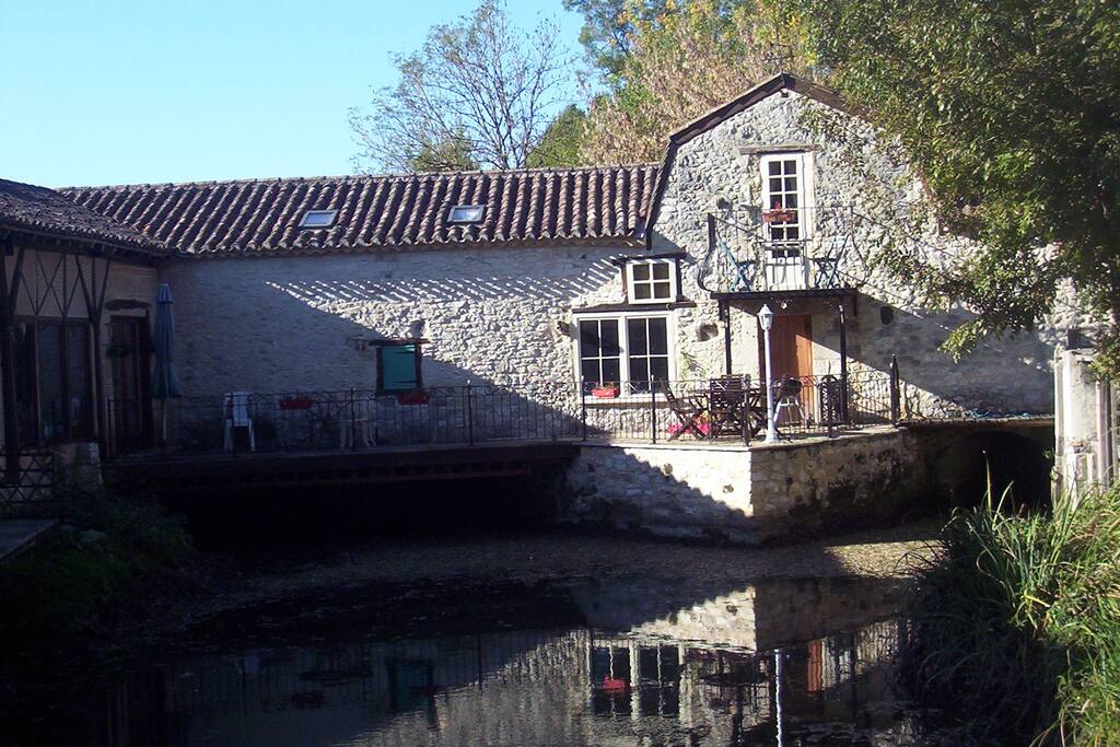 Rear terrace with seating area and parasols overlooking the river and grounds