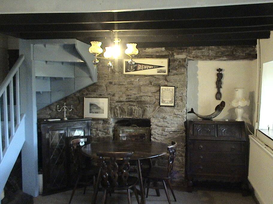 Shows the dining table & desk which is next to the internet modem, & living room heating